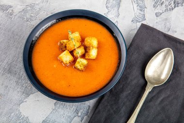 Kızarmış ekmek ve taze maydanozlu domates çorbası.