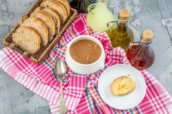 Famous French dish, French onion soup. Caramelised onions cooked in stock with wine and herbs, topped with toasted baguette and cheese and finished under the grill.