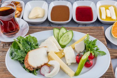 Türk usulü kahvaltı; Geleneksel Türk kahvaltı tabağı masada, üst manzara. Parlak bir sabahta sağlıklı Türk kahvaltısı.