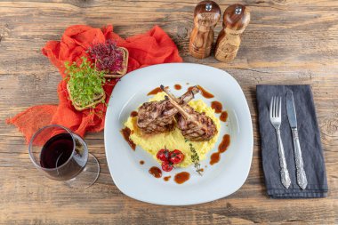Kuzu pirzolası, ahşap arka planda kırsal mutfak masasında kuzu kaburgası. Patates püresi ile servis edilen kuzu kaburgası.