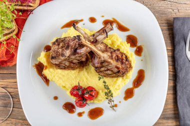 Kuzu pirzolası, ahşap arka planda kırsal mutfak masasında kuzu kaburgası. Patates püresi ile servis edilen kuzu kaburgası.