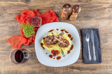 Kuzu pirzolası, ahşap arka planda kırsal mutfak masasında kuzu kaburgası. Patates püresi ile servis edilen kuzu kaburgası.