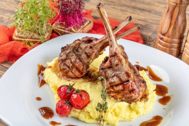 Kuzu pirzolası, ahşap arka planda kırsal mutfak masasında kuzu kaburgası. Patates püresi ile servis edilen kuzu kaburgası.