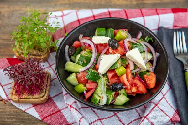 Mediterranean Salad (Greek salad) with fresh vegetables, feta cheese and black olives. Top view.