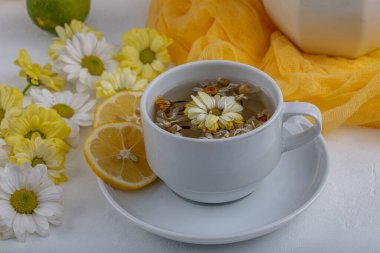 Beyaz arka planda papatya çiçekli bitki çayı. Sağlıklı içecek..