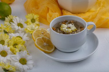 Beyaz arka planda papatya çiçekli bitki çayı. Sağlıklı içecek..