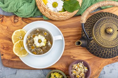 Çaydanlık papatya çayı döküyorum. Doğulu çay demliği ve çay fincanı..