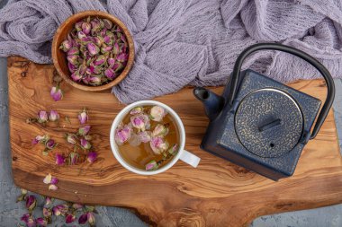 Geleneksel Asya bitkisel çayıyla yaşam klasik dökme demir çaydanlıkla hazırlanıyor. Kırsal ahşap masa üzerinde organik kuru otlar var. Retro filtresi.