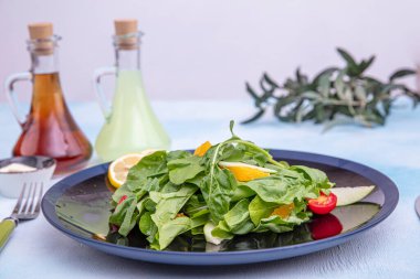 Arugula salatası. Parmesan peynirli roket salatası, limon, zeytinyağı ve ahşap arka planda baharatlar. Vejetaryen yemeği.