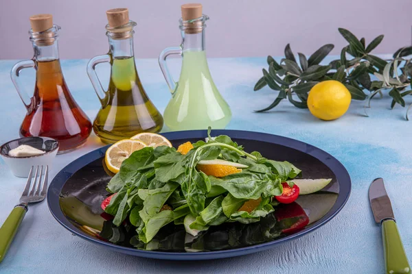 Arugula salad. Rocket salad with Parmesan cheese, lemon, olive oil and seasonings on wooden background. Vegetarian food