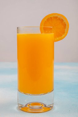 Bir bardak taze portakal suyu ve ahşap masada taze meyveler.