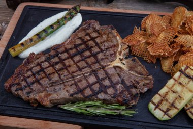 Et lokantasında servis edilen taze otlar ve salamura ile tatlandırılmış ızgara biftek. Lezzetli restoran yemekleri.