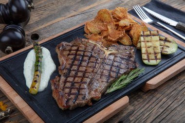 Et lokantasında servis edilen taze otlar ve salamura ile tatlandırılmış ızgara biftek. Lezzetli restoran yemekleri.