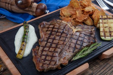 Et lokantasında servis edilen taze otlar ve salamura ile tatlandırılmış ızgara biftek. Lezzetli restoran yemekleri.