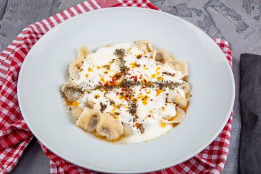 Mükemmel Türk Ravioli 'si ve tereyağında kızartılmış acı biber. Ev yapımı lezzetli Türk mantisi (Türk mantısı) yoğurt ve soslu..