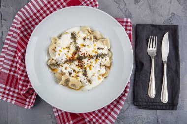 Mükemmel Türk Ravioli 'si ve tereyağında kızartılmış acı biber. Ev yapımı lezzetli Türk mantisi (Türk mantısı) yoğurt ve soslu..