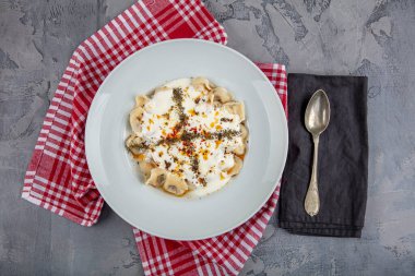 Mükemmel Türk Ravioli 'si ve tereyağında kızartılmış acı biber. Ev yapımı lezzetli Türk mantisi (Türk mantısı) yoğurt ve soslu..