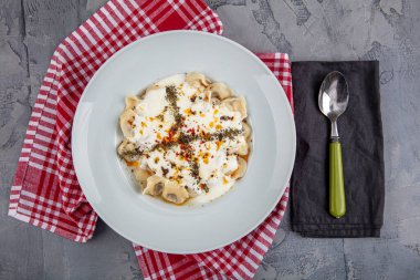 Mükemmel Türk Ravioli 'si ve tereyağında kızartılmış acı biber. Ev yapımı lezzetli Türk mantisi (Türk mantısı) yoğurt ve soslu..