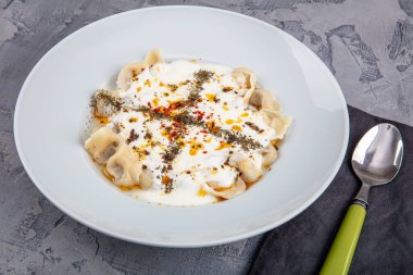 Mükemmel Türk Ravioli 'si ve tereyağında kızartılmış acı biber. Ev yapımı lezzetli Türk mantisi (Türk mantısı) yoğurt ve soslu..