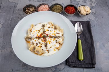 Mükemmel Türk Ravioli 'si ve tereyağında kızartılmış acı biber. Ev yapımı lezzetli Türk mantisi (Türk mantısı) yoğurt ve soslu..