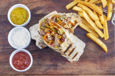 Tortilla sandviçleri taze sebzelerle sarar, kıyma yapar ve patates kızartmasıyla servis edilir. Burrito, sandviç, fajita dürümü..