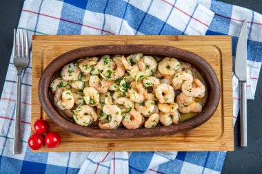 Ahşap zemin üzerinde karides olan güveç..