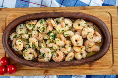 Ahşap zemin üzerinde karides olan güveç..