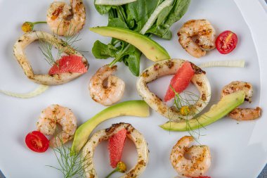 Kızarmış kalamar halkalı deniz ürünleri tabağı taze roka üzerine limonla süslenmiş karides. Akdeniz aperatifleri. Üst görünüm