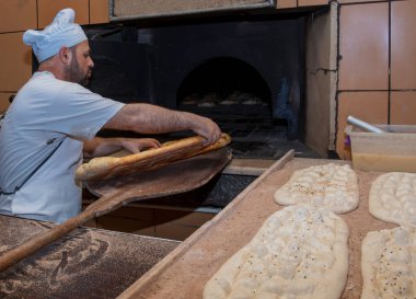  Türk pide ekmeği yapan bir fırıncı. Fırın, Türk pide ekmeği. Fırından taze Türk pidesi ekmeği alıyor. Türk Ramazan Pita üretim süreci.