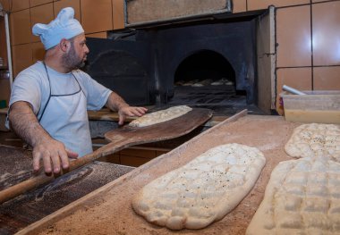  Türk pide ekmeği yapan bir fırıncı. Fırın, Türk pide ekmeği. Fırından taze Türk pidesi ekmeği alıyor. Türk Ramazan Pita üretim süreci.