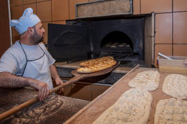  Türk pide ekmeği yapan bir fırıncı. Fırın, Türk pide ekmeği. Fırından taze Türk pidesi ekmeği alıyor. Türk Ramazan Pita üretim süreci.