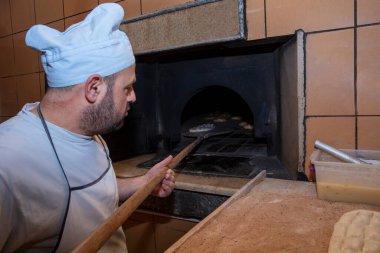  Türk pide ekmeği yapan bir fırıncı. Fırın, Türk pide ekmeği. Fırından taze Türk pidesi ekmeği alıyor. Türk Ramazan Pita üretim süreci.