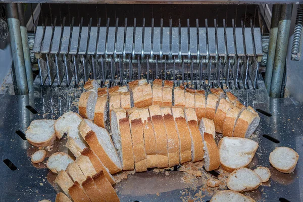 Sliced  Bread in Cutting Machine / Industrial Bread Slicer in Supermarket with Bread Crumbs. Ready to Use.