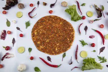 Beyaz arka planda yeşil sebzeler arasında Türk Lahmacunu. Lahmacun Restoranı konsepti.