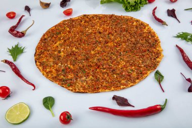 Beyaz arka planda yeşil sebzeler arasında Türk Lahmacunu. Lahmacun Restoranı konsepti.