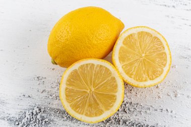 Beyaz ahşap arka planda dilimlenmiş taze limon. Düz konum, üst görünüm, kopyalama alanı. Minimum meyve konsepti tasarımı. Sarı narenciye, limon.