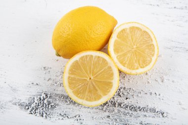 Beyaz ahşap arka planda dilimlenmiş taze limon. Düz konum, üst görünüm, kopyalama alanı. Minimum meyve konsepti tasarımı. Sarı narenciye, limon.