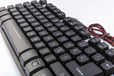 Bilgisayar klavyesi. Beyaz arka planda kablosu olan siyah klavye.