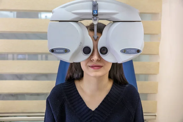 관리를 안과의 안과의 안과에서 관리를 여성에게 쌍안경의 램프를 사용하여 안과에서 — 스톡 사진