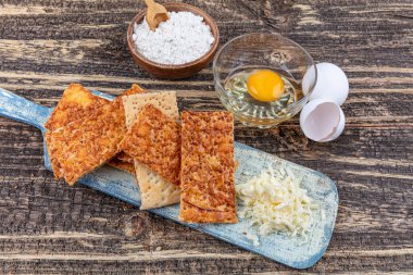 Kırsal ahşap kasede susam tohumlu ev yapımı ince çıtır peynirli krakerler. Taze organik ev yapımı peynirli krakerler.