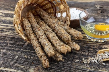 Tahta zemin üzerinde ayçiçeği tohumlu bir buğday yığını Grissini ekmeği..