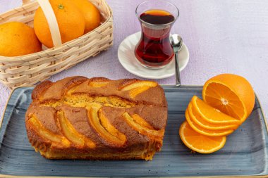 Üzerinde taze portakal dilimleri olan portakallı kek.