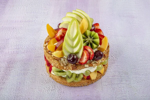 Mixed fruit cake, Fruits pastry pink wooden background.