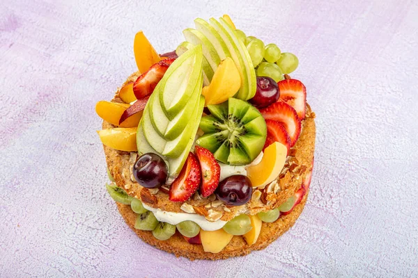 Mixed fruit cake, Fruits pastry pink wooden background.