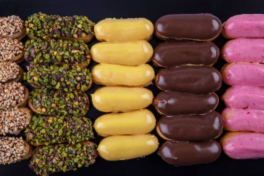 Ekler Pasta / Çikolatalı Donut tabakta. Bir sürü Fransız profiterol (eclair) choux pastası..