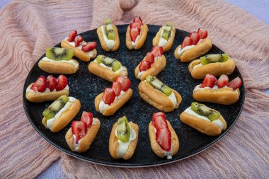 Siyah tabakta kivi ve çilekli Ekler makarna / Çikolatalı Donut.