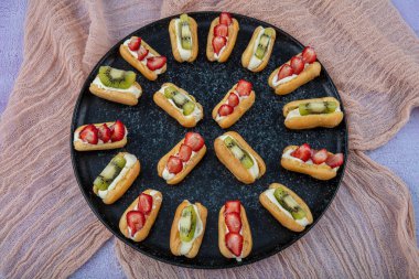 Siyah tabakta kivi ve çilekli Ekler makarna / Çikolatalı Donut.