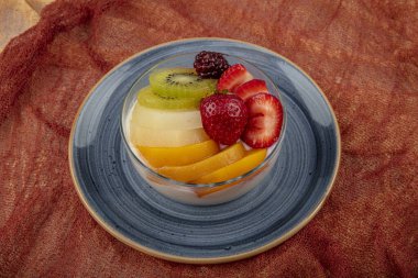 Bir kase taze meyveli kremalı puding..