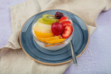 Bir kase taze meyveli kremalı puding..