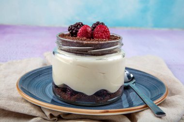 Manolya Tatlısı. Blackberry ve Magnolia. Ahşap zemin üzerinde cam bardakta manolya tatlısı..